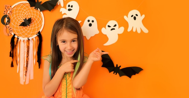 Dziewczyna Malująca Dwoma Palcami Na Bok W Przestrzeni Kopii Na Pomarańczowym Tle Halloween