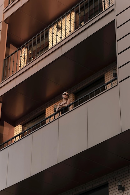Dziewczyna na balkonie wielopiętrowego budynku