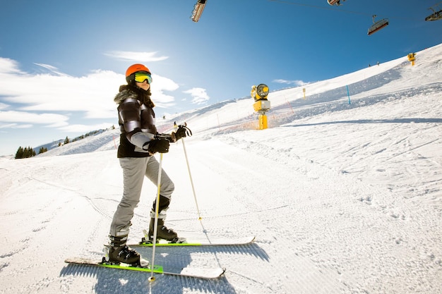 Dziewczyna na nartach zimą rozkoszuje się przygodą w słoneczny dzień