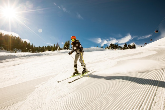 Dziewczyna na nartach zimą rozkoszuje się przygodą w słoneczny dzień