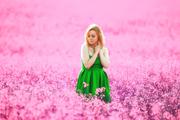 dziewczyna na polu kwiatów bzu w lawendowych kolorach, fioletowo-różowy krajobraz, szczęśliwa i harmonijna