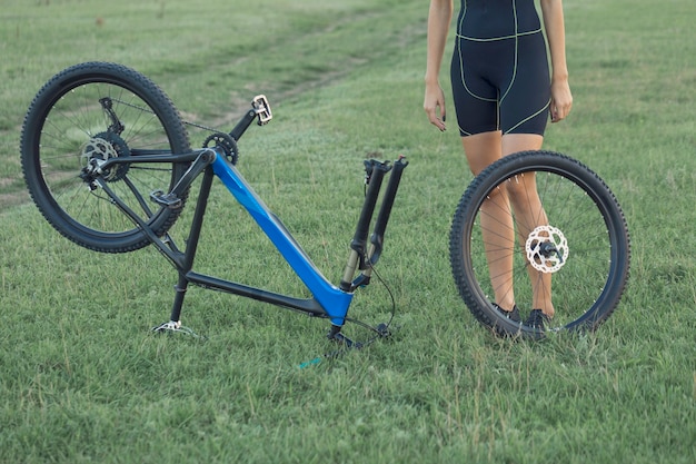 Dziewczyna na rowerze górskim w terenie Dziewczyna fitness jeździ na nowoczesnym rowerze górskim z włókna węglowego