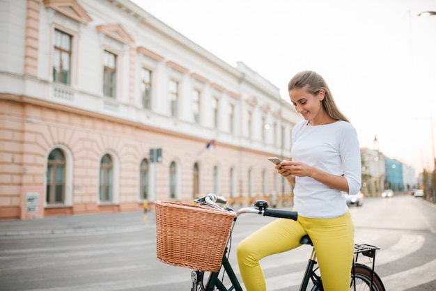 Dziewczyna na rowerze za pomocą telefonu.