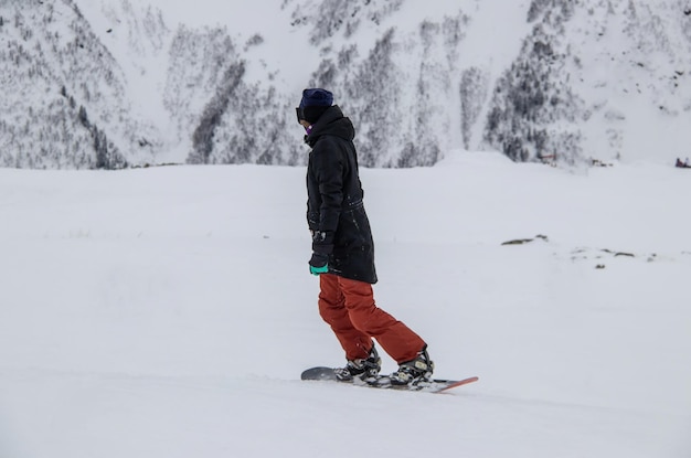 Zdjęcie dziewczyna na snowboardzie zjeżdża po zboczu góry