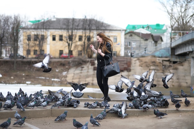 Dziewczyna na spacerze po parku i stado gołębi
