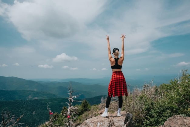 Dziewczyna na szczycie góry Falaza patrzy na piękną górską dolinę Podróże i turystyka Piesze wycieczki