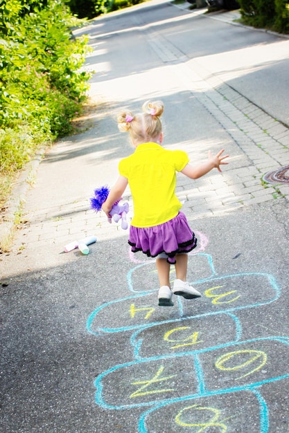Dziewczyna na ulicy grająca w hopscotch