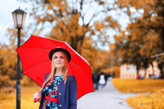 Dziewczyna na ulicy z parasolką na spacer w jesienny dzień