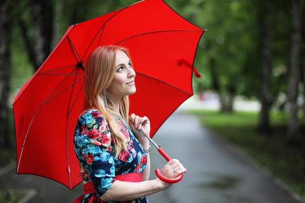Dziewczyna na ulicy z parasolką na spacer w letni dzień