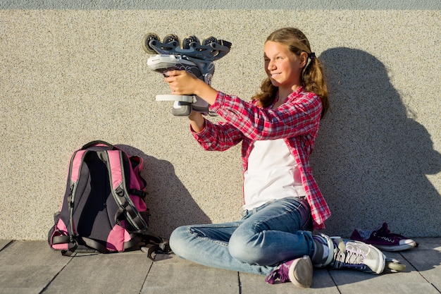 Zdjęcie dziewczyna nastolatka siedzi na ścianie obok plecaka