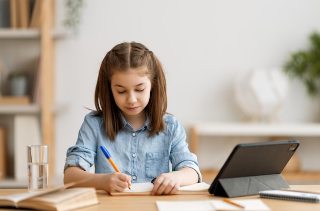 Dziewczyna odrabiająca pracę domową lub edukację online