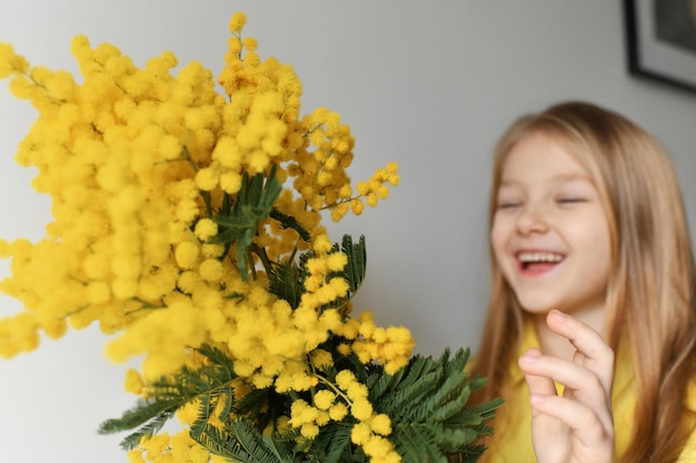 Dziewczyna pachnąca żółtą mimozą na wiosnę