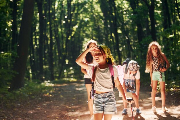 Dziewczyna patrząca daleko Dzieci spacerujące po lesie ze sprzętem podróżnym