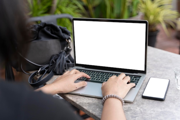 Dziewczyna pisząca na laptopie ze słuchawkami w okularach pustego ekranu i długopisem na drewnianym stole makieta