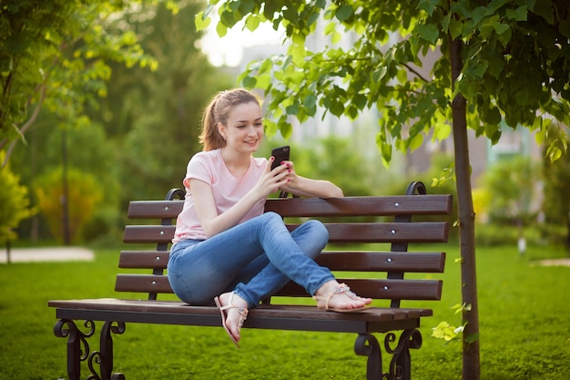 Dziewczyna Pisze Na Telefonie Siedząc W Parku