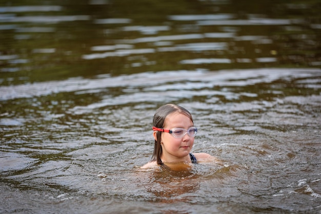 Zdjęcie dziewczyna pływa w rzece w upalny letni dzień