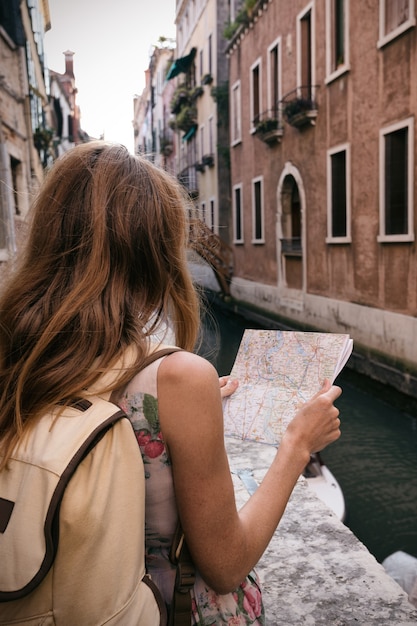 Dziewczyna podróżnik patrzy na mapę chodzenia w Wenecji, Włochy