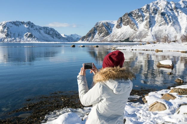 Dziewczyna podróżuje po Lofotach i robi zdjęcia aparatem. piękny norweski krajobraz. Norwegia