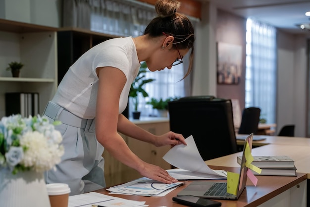 Zdjęcie dziewczyna pracująca na biurku biznesowa kobieta zajęta papierkową robotą i laptopem w nowoczesnej koncepcji biura biznesowego