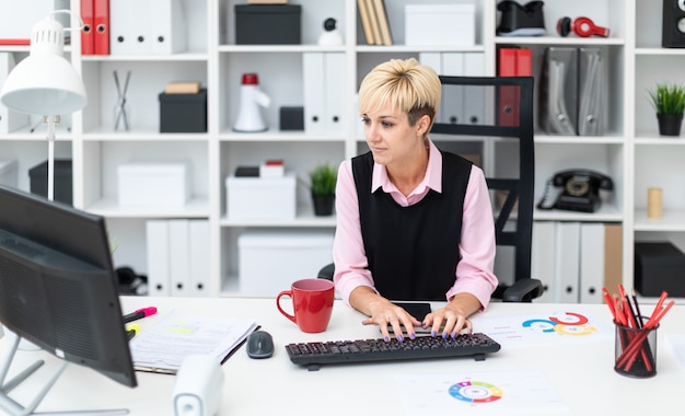 Zdjęcie dziewczyna pracuje w biurze przy komputerze.
