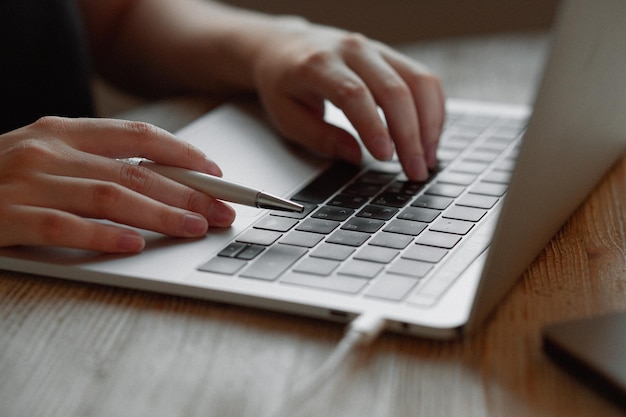 Dziewczyna pracuje w domu przy laptopie Dłoń na touchpadzie, palec klika informacje