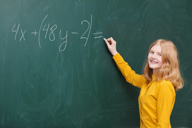 Dziewczyna robi matematyki na tablicy szkolnej