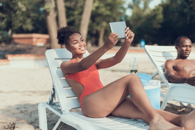 Dziewczyna robi Selfie na komputerze typu Tablet. Słoneczny dzień na plaży