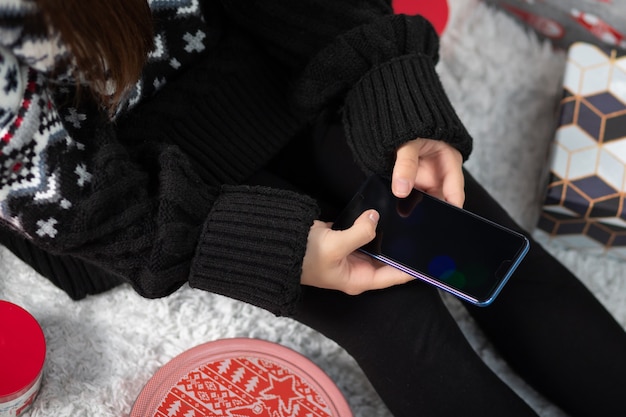 Dziewczyna robi świąteczne zakupy online na smartfonie