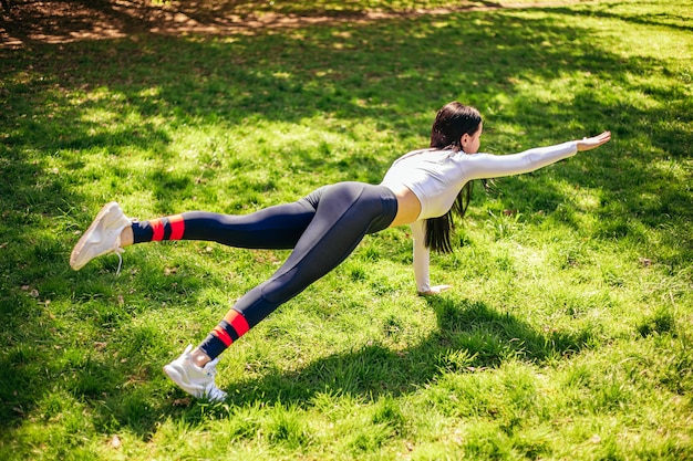 Zdjęcie dziewczyna rozciągająca przygotowuje swoje ciało i mięśnie do wydajnego treningu fitness