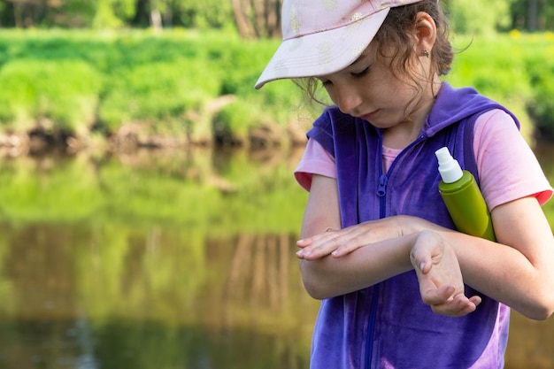 Dziewczyna rozpyla spray na komary na skórze w naturze, który ugryzie ją w dłonie i stopy Ochrona przed ukąszeniami owadów środek odstraszający bezpieczny dla dzieci Rekreacja na świeżym powietrzu przeciw alergiom Czas letni