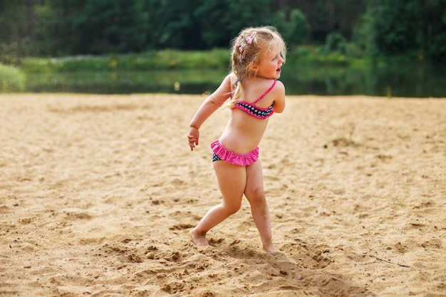 Dziewczyna rzuca piaskiem Piękna dziewczyna bawi się piaskiem na plaży