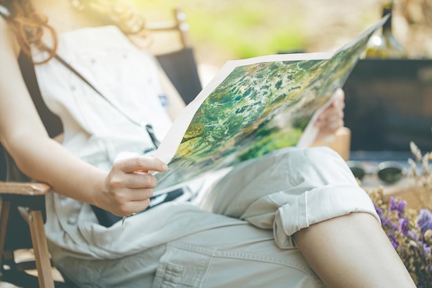 Zdjęcie dziewczyna siedzi i patrzy na mapę nad strumieniem