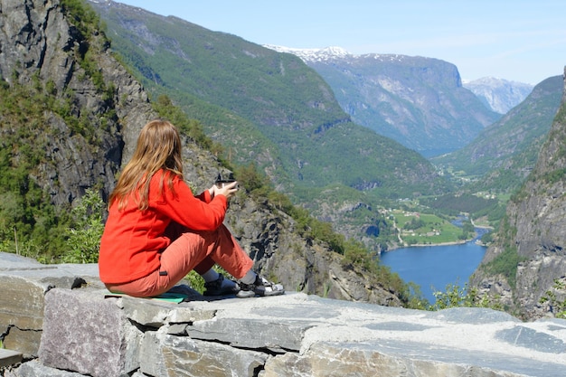 Dziewczyna siedzi na parapecie i patrzy na piękny krajobraz