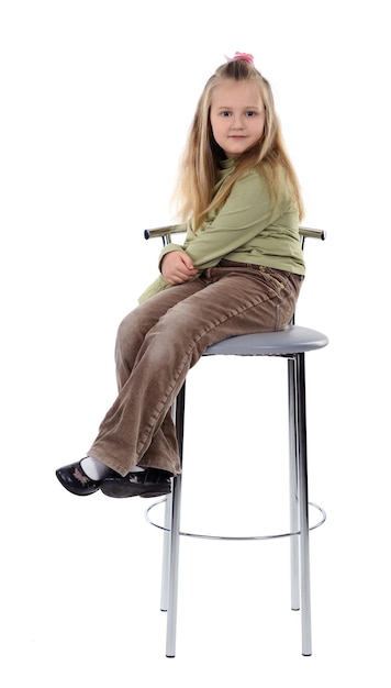 Dziewczyna siedzi na wysokim krześle na białym tle