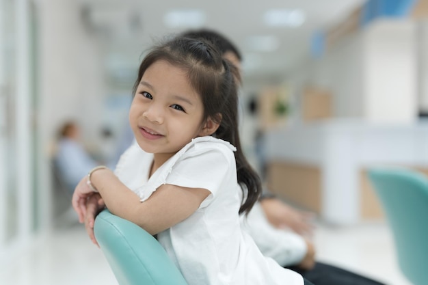 Dziewczyna siedzi uśmiechając się w holu szpitala