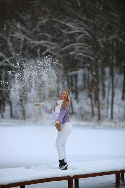 Dziewczyna spaceruje po małym moście nad jeziorem Zimowe piękno jest wszędzie