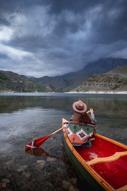 dziewczyna spływa kajakiem po jeziorze w górach w pochmurny dzień nastrojowa atmosfera na jeziorze bylym