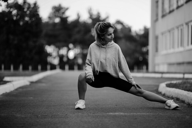 dziewczyna sportowiec zaangażowana w sportAtletyczna młoda kobieta robi poranne ćwiczenia czarno-białe zdjęcie