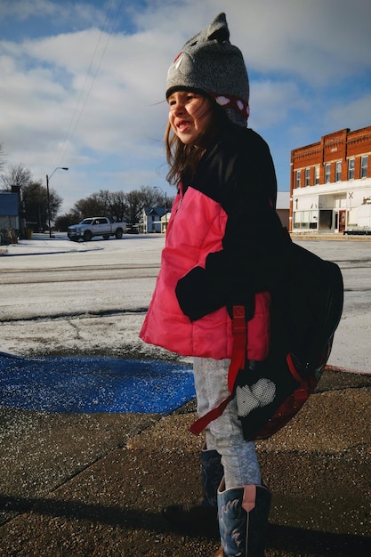 Zdjęcie dziewczyna stojąca na ulicy w mieście w zimie