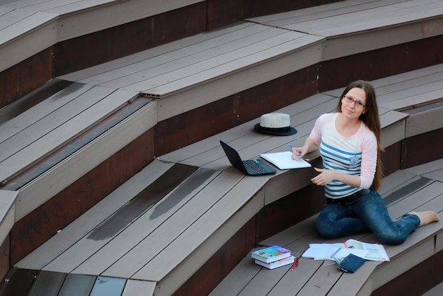 Dziewczyna studentka praca domowa na zewnątrz