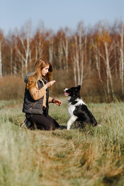 Dziewczyna trenująca czarno-białe szczenię rasy border collie