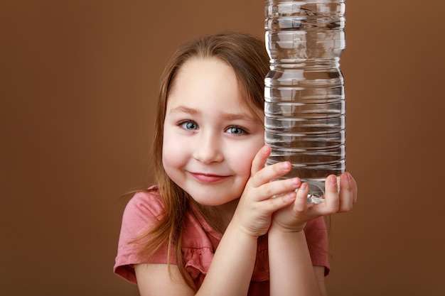 Dziewczyna trzyma butelkę wody w rękach