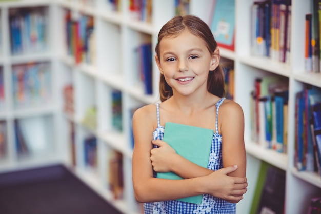 Dziewczyna trzyma książkę w bibliotece