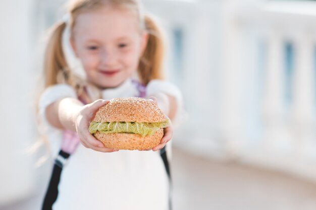 Dziewczyna Trzyma świeżego Hamburgera Z Sałatą