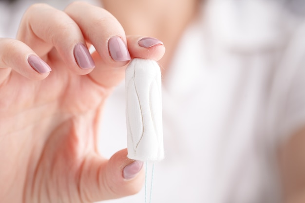 Dziewczyna Trzyma Tampon Podczas Cyklu Miesięcznego. Młoda Kobieta Ręce Trzyma Miesiączki Bawełny Tampon