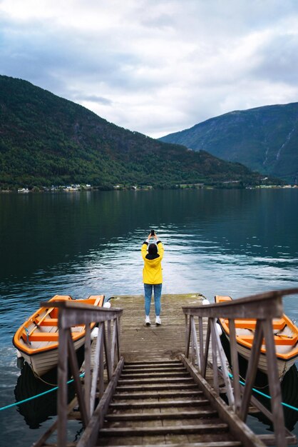 Dziewczyna turystyczna w żółtej kurtce Aktywna kobieta relaksująca się w Norwegii Podróżująca przygoda życia