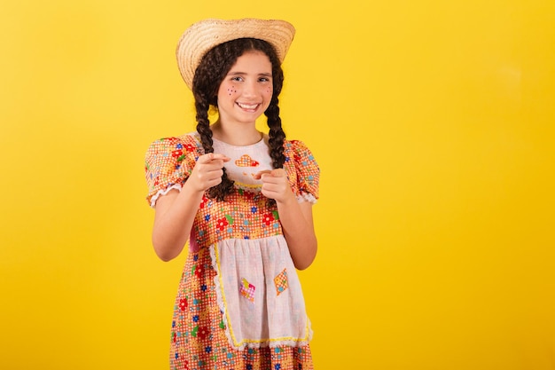 Dziewczyna Ubrana W Tradycyjne Pomarańczowe Ubrania Na Festa Junina Wskazując Palcami, Które Wybrałeś