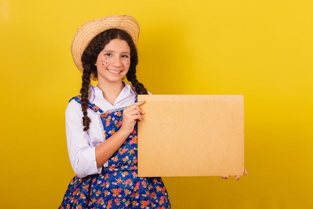 Dziewczyna ubrana w typowe ubrania na Festa Junina trzymająca ekran na tekst lub reklamę Na imprezę Arraia