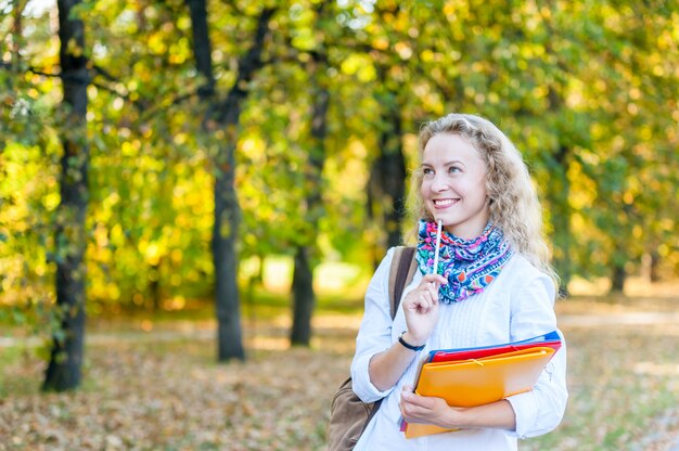 Dziewczyna Uczeń Uśmiecha Się Stertę Falcówki W Autum I Trzyma