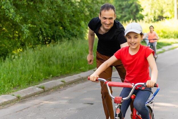 Dziewczyna uczy się jeździć na rowerze.